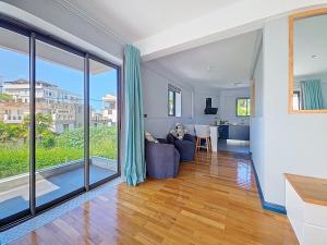 Una sala de estar con un sofá y grandes ventanales. en Blue Waves, en Blue Bay