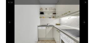 een witte keuken met witte kasten en een spoelbak bij Ferienwohnung in Bad Saarow in Bad Saarow