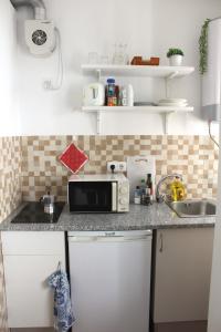 a kitchen counter with a microwave and a sink at Cubo in Lagos