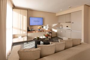 a living room with a couch and a table and a kitchen at Citadines Almaz Aparthotel Casablanca in Casablanca