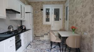 een keuken met witte kasten en een tafel en stoelen bij RegistanStay - Private House 2 Min Walk to Registan in Samarkand