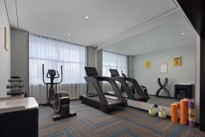 ein Fitnessstudio mit Laufbändern und Crosstrainern in einem Raum in der Unterkunft Huanzhi Hotel Hulunbuir Hailar Railway Station Branch in Hulunber