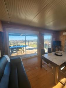 a living room with a table and a view of a patio at La tête sous les étoiles in Lézignan-la-Cèbe