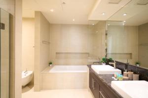 ein Badezimmer mit zwei Waschbecken und einer Badewanne in der Unterkunft Luxury Stay on Saadiyat Island - Pool, Gym, Parking in Abu Dhabi