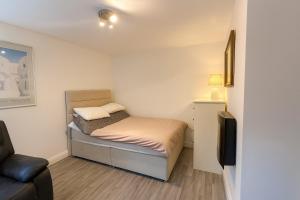 een kleine slaapkamer met een bed en een televisie bij Modern Tiny Home - Ideal for Work Stays & Parking in Pocklington