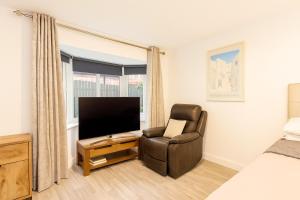 een woonkamer met een stoel en een televisie bij Modern Tiny Home - Ideal for Work Stays & Parking in Pocklington