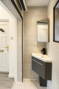 een badkamer met een wastafel en een spiegel bij Modern Tiny Home - Ideal for Work Stays & Parking in Pocklington