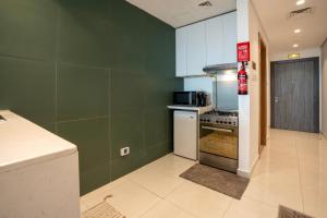 a kitchen with green walls and a stove top oven at Appartement Dubai in Dubai