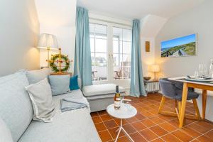 ein Wohnzimmer mit Sofa und Tisch in der Unterkunft Syltweh in Munkmarsch + 8 Fotos