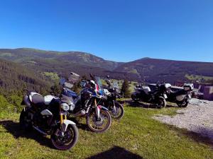 a group of motorcycles parked on a hill with mountains in the background at Bílá Labuť Pec in Pec pod Sněžkou +58 photos