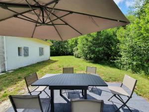 een zwarte tafel met stoelen en een paraplu bij Maison perouge in Soustons