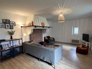 een woonkamer met een bank en een open haard bij Maison perouge in Soustons