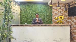 a man in a suit sitting at a counter at Basil Inn in Pune