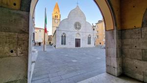 an archway leading to a church with a clock tower at Alle Pratoline Casa vacanze spaziosa vicino Trieste e mare con deposito bici e moto coperto in Muggia