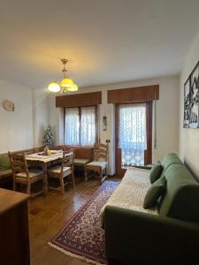 a living room with a green couch and a dining room at Cesira in Mareson