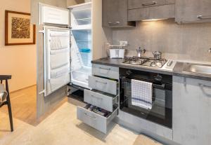 a kitchen with a stove and an open refrigerator at HouSmart Montanara 606-2 in Vignola +20 photos