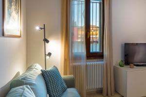 a living room with a blue couch and a television at HouSmart Montanara 606-2 in Vignola