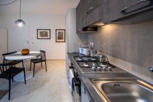 a kitchen with a sink and a stove and a table at HouSmart Montanara 606-2 in Vignola