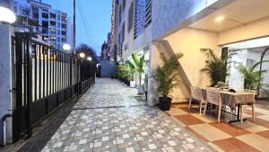 a walkway with tables and plants on a building at Basil Inn in Pune +12 photos