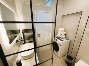 a white bathroom with a toilet and a window at Ghini Venes 3 in Tríkala