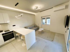 a kitchen and living room with a white counter top at Ghini Venes 3 in Tríkala