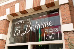 a window with a sign that says hello to a store at Hotel La Bohème in Amsterdam