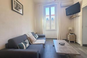 1-bedroom appartement in the center of Cannes في كان: غرفة معيشة مع أريكة زرقاء وطاولة قهوة