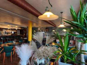 a restaurant with tables and potted plants at Pension Hafenblick in Barth