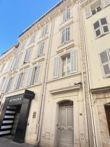 1-bedroom appartement in the center of Cannes في كان: مبنى ابيض كبير امامه باب +9 صور