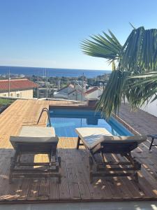 un patio con 2 sedie e una piscina di Sea View Sunrise Luxury Apartment a Città di Rodi