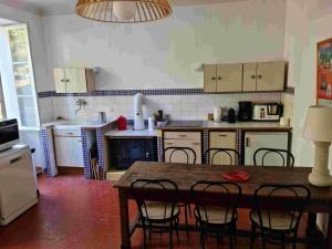 eine Küche mit einem Tisch und Stühlen darin in der Unterkunft Pécoule in Bevons