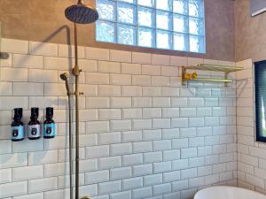 恒春古城西晒旅宿墾丁包棟的带淋浴和卫生间的浴室以及窗户。 更多12张照片