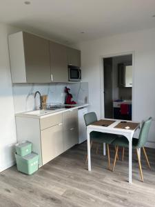 una cucina con un tavolo e un tavolo e sedie di Sof tiny a Moyenmoutier