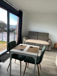 un soggiorno con tavolo, sedie e divano di Sof tiny a Moyenmoutier