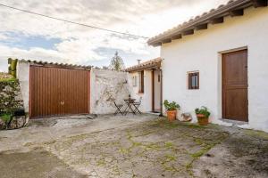 una casa blanca con una puerta de madera y un patio en Celada Una casina con encanto, en Celorio