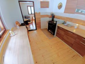 a kitchen with a stove and a wooden floor at Chata Bachláč, Jarabá in Jarabá