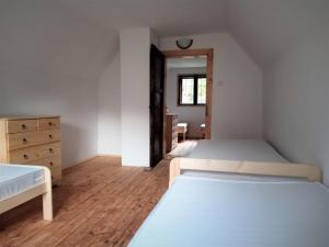 a bedroom with two beds and a wooden floor at Chata Bachláč, Jarabá in Jarabá +4 photos