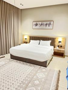 a bedroom with a large white bed and a rug at جده شارع صاري in Jeddah