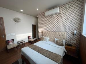 een slaapkamer met een groot bed en een muur bij Hotel LAVENIR in Rohtak +36 foto's