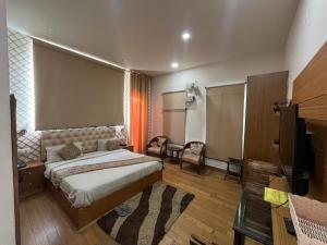 een slaapkamer met een bed en een flatscreen-tv bij Hotel LAVENIR in Rohtak