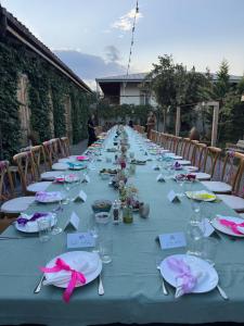 a long table with plates and napkins on it at Nikalas Marani in Gurjaani