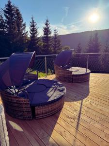 a deck with two chairs and an umbrella on it at Bílá Labuť Pec in Pec pod Sněžkou
