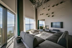 - un salon avec un canapé et de grandes fenêtres dans l'établissement Vista Hills Excelsior, à Mošćenice