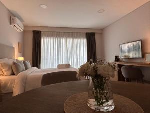 a living room with a bed and a vase of flowers on a table at Soar Luxury Studio en el centro de Salta in Salta