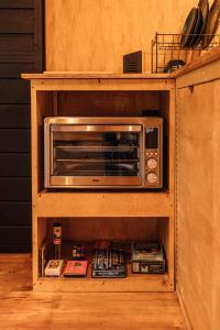 ein Toasterofen in einem Holzschrank in der Unterkunft Cabana Fora in São Francisco de Paula