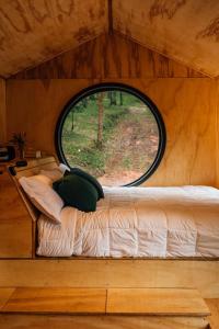 Bett in einem kleinen Zimmer mit Fenster in der Unterkunft Cabana Fora in São Francisco de Paula