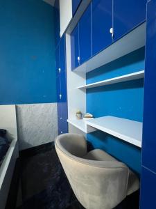 een badkamer met blauwe muren en een stoel bij Riyaanz aesthetic in Hyderabad