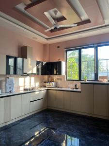 een grote keuken met witte kasten en een plafond bij Riyaanz aesthetic in Hyderabad +25 foto's