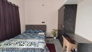a bedroom with a bed and a desk at Anand stay in Dānāpur