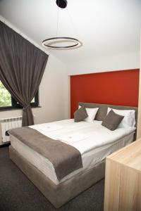 a bedroom with a large bed with a red wall at Datcha Tsaghkadzor in Tsaghkadzor